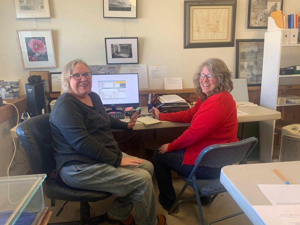 two people working at a computer in an office