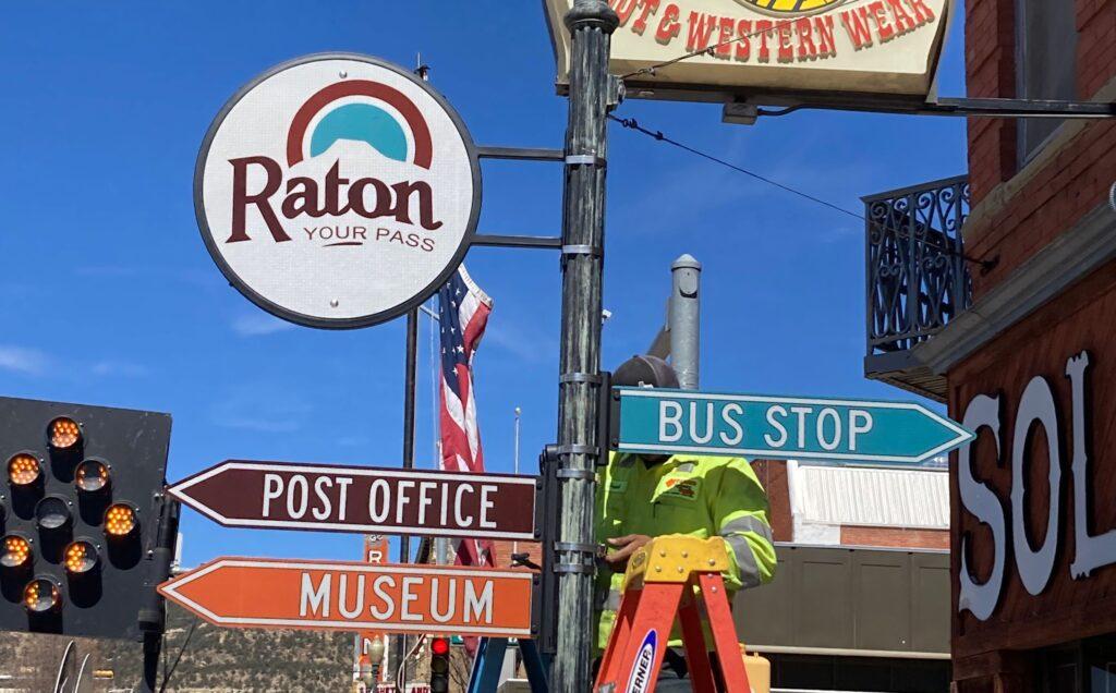 colorful directional signs on a city street being installed