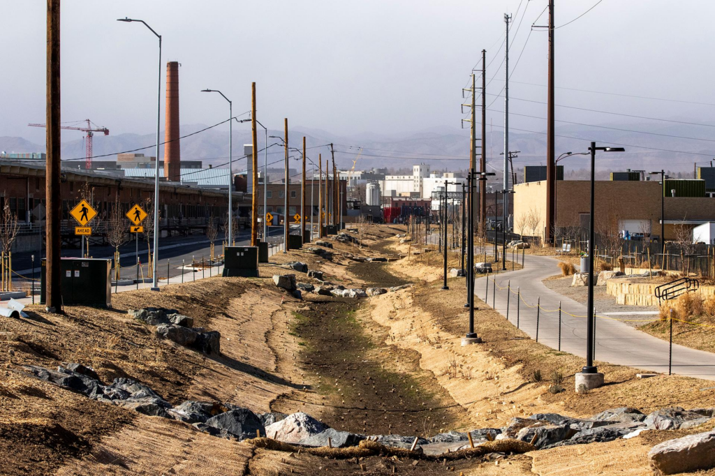 A drainage ditch lined with street lights, electrical poles