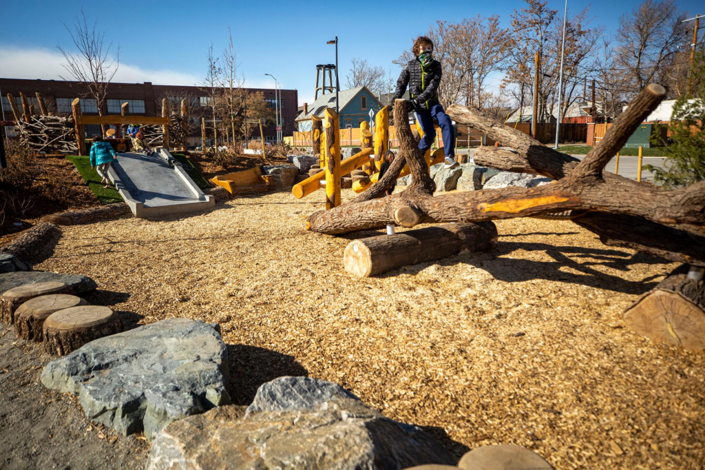 Kids play on a playground along the 39th Avenue Greenway