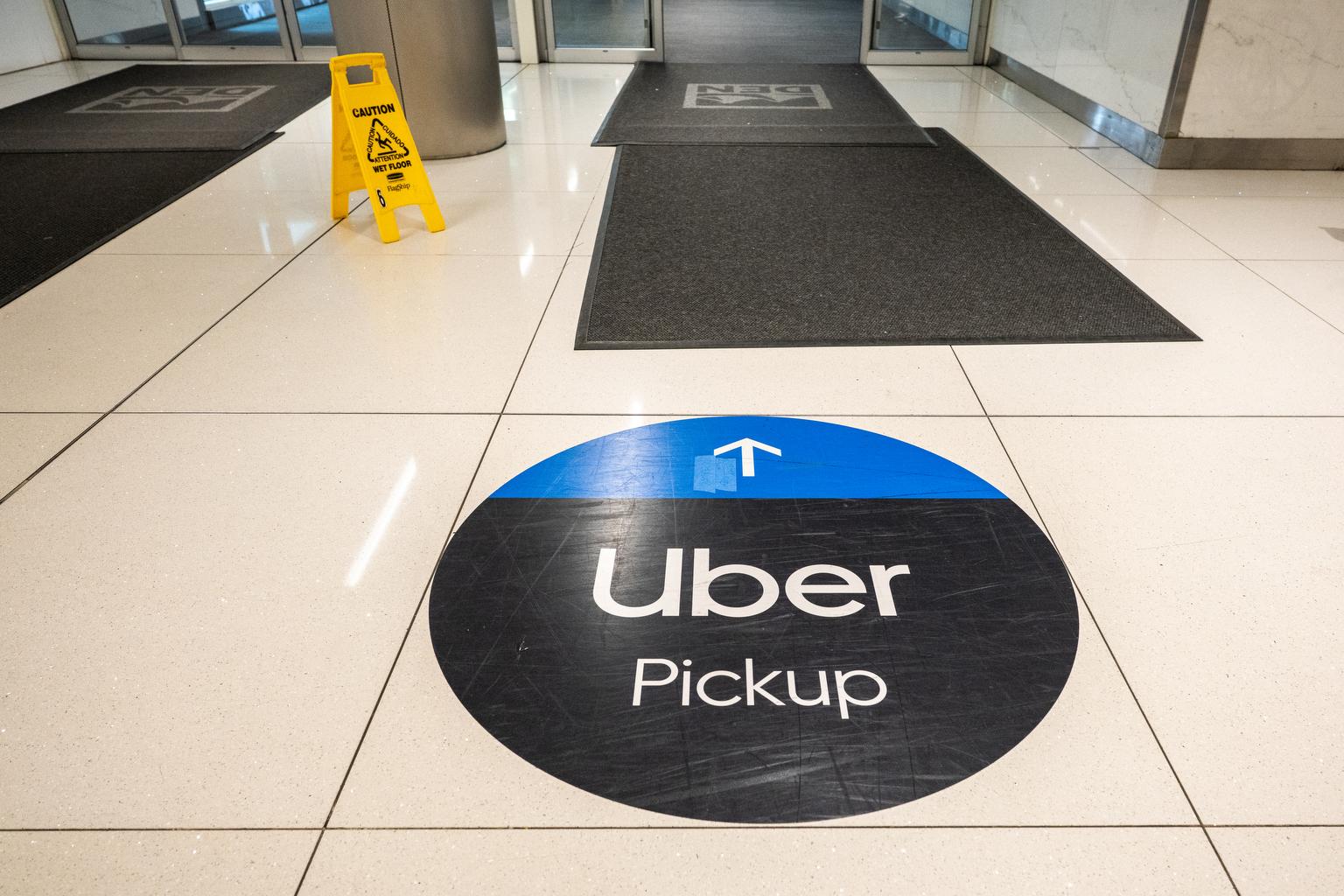 A floor sign points the way to Uber’s pickup location at Denver International Airport