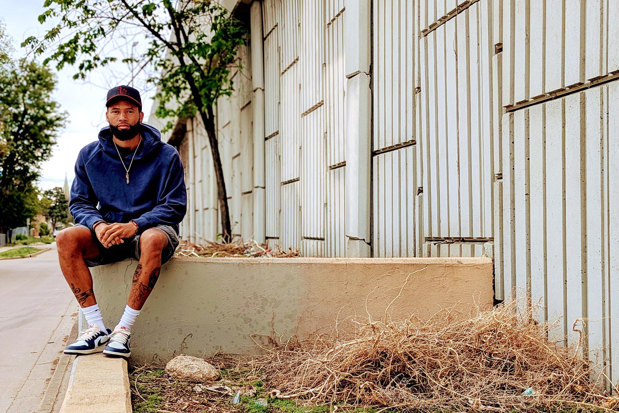 A man sits on a concrete wall