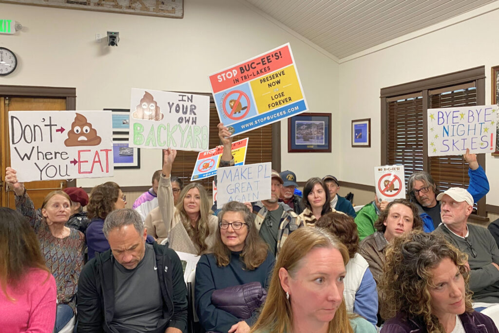 People hold signs opposing a proposal that would add a Buc-ee's Travel Center to Palmer Lake.