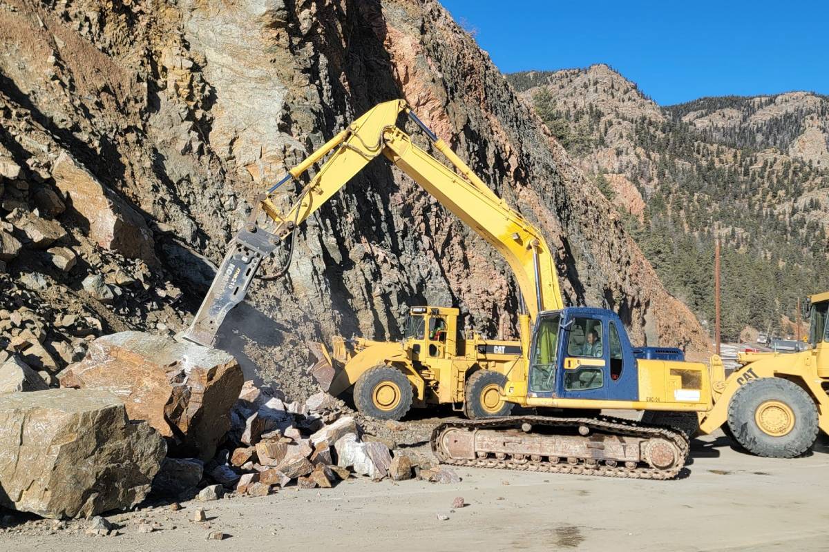 machines clear rocks after a rockslide on a highway