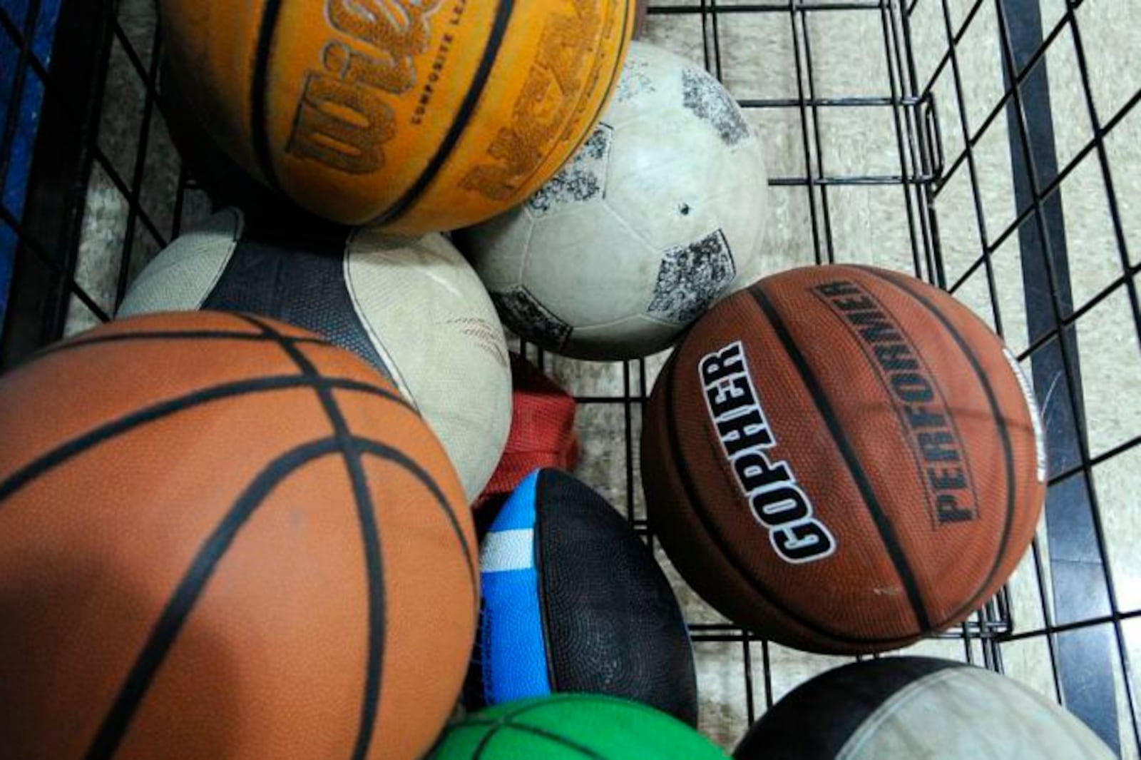 a wire basket with sports balls