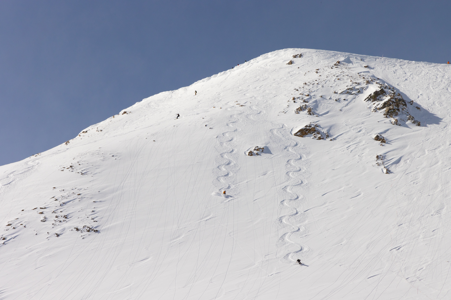 zigzags from two tiny skiers on a large mountain.