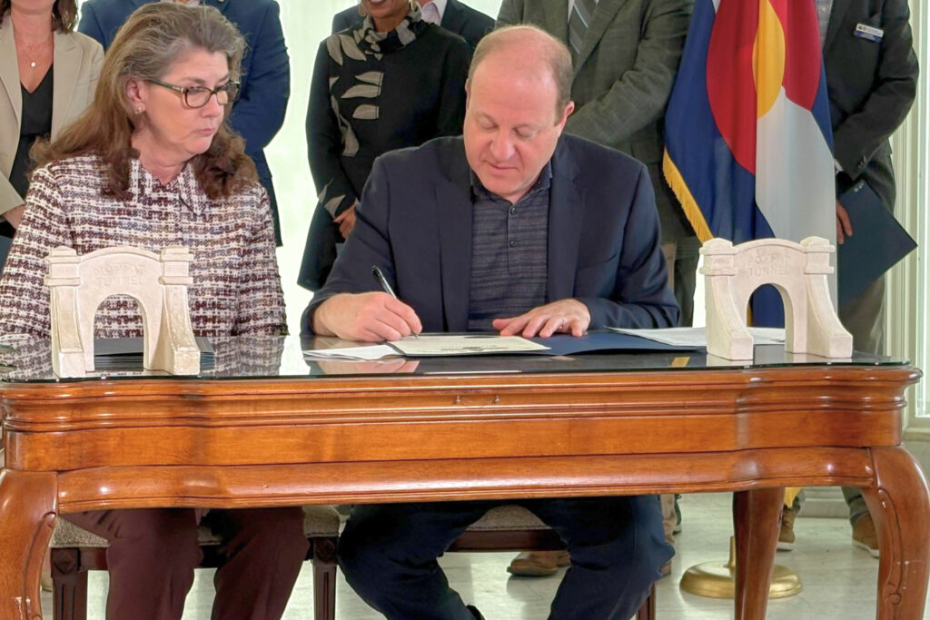 man signing paper while sitting down