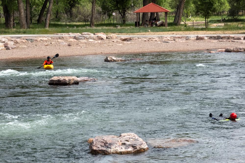 a kayaker and a person float in the river