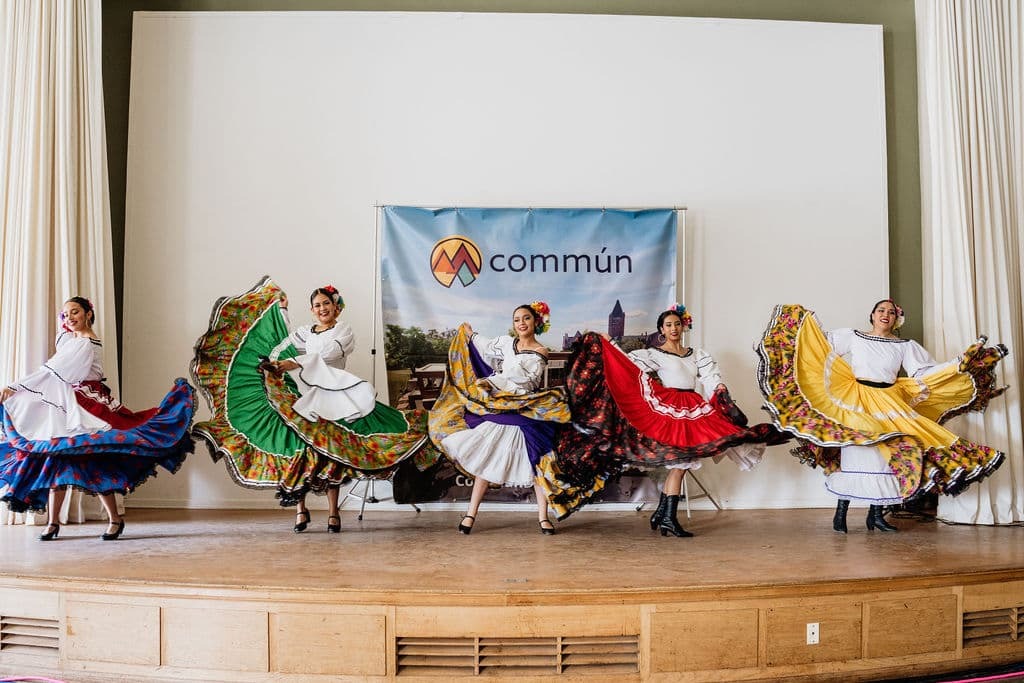 Six dancers on top of a stage at a celebration