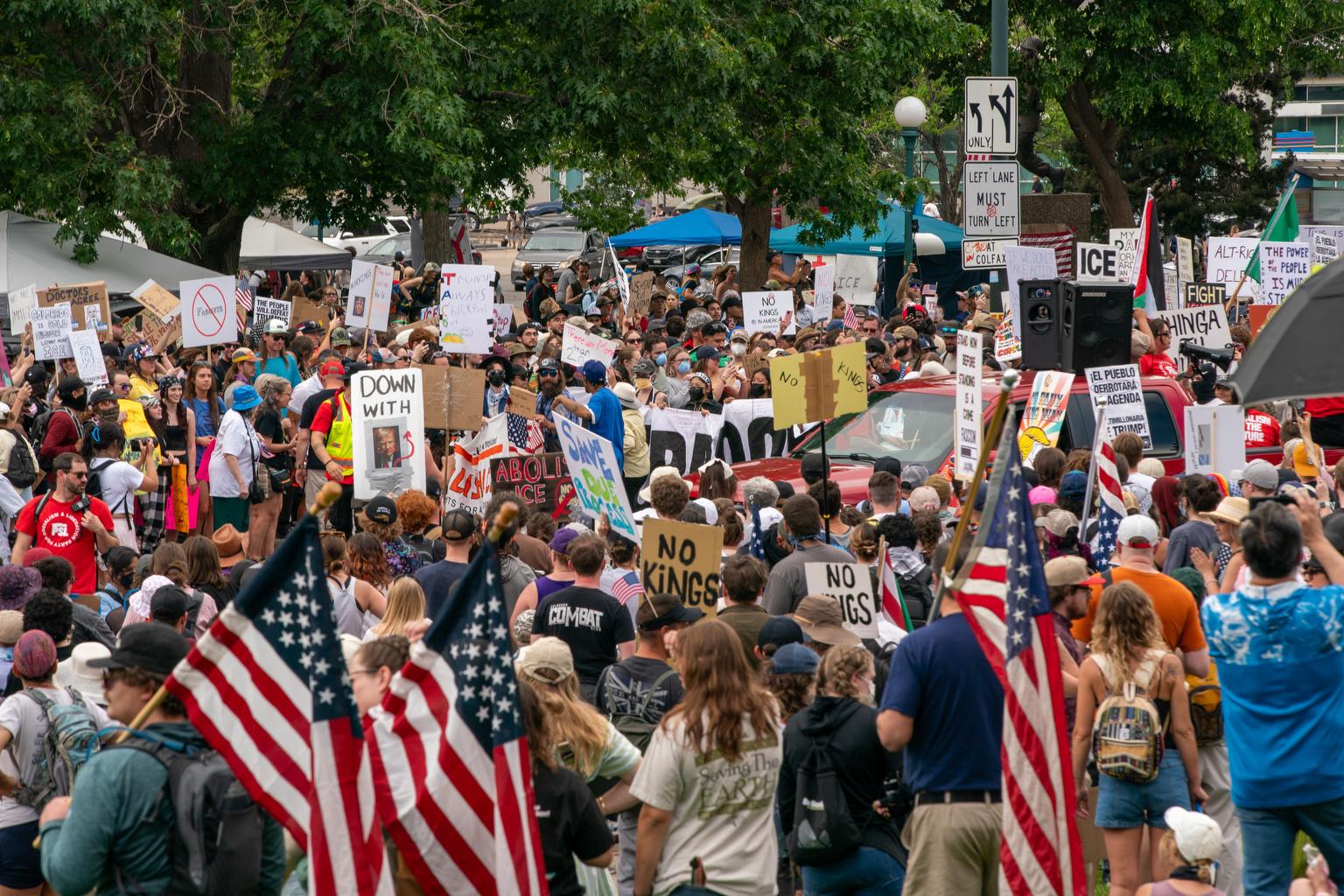 Thousands of marchers line up behind a banner declaring Colorado Stands With Immigrants