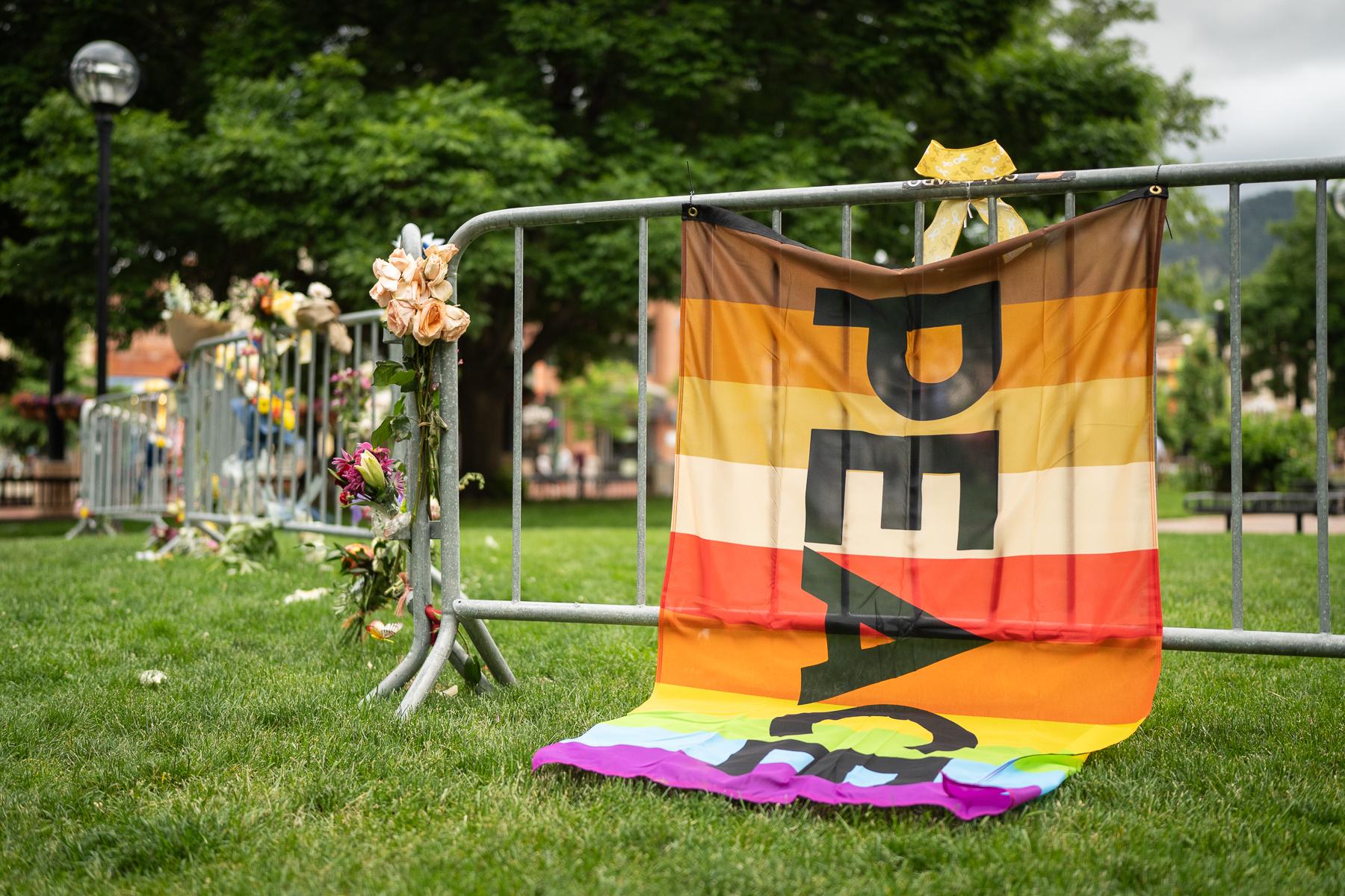 Flowers and flags adorn a makeshift memorial in Boulder
