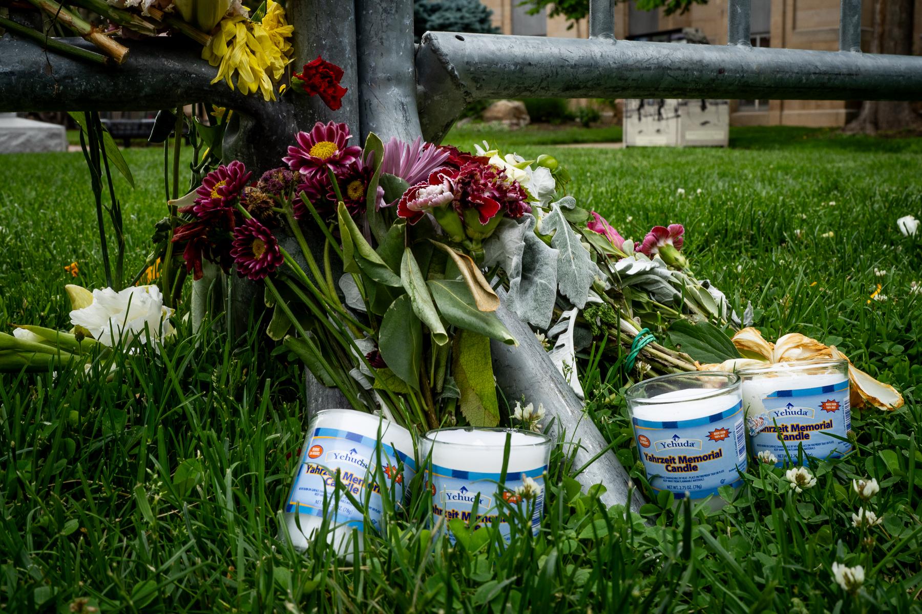 Flowers and flags adorn a makeshift memorial in Boulder