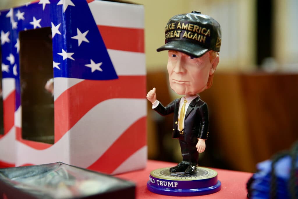 A bobblehead doll in the likeness of Donald Trump rests on a table.