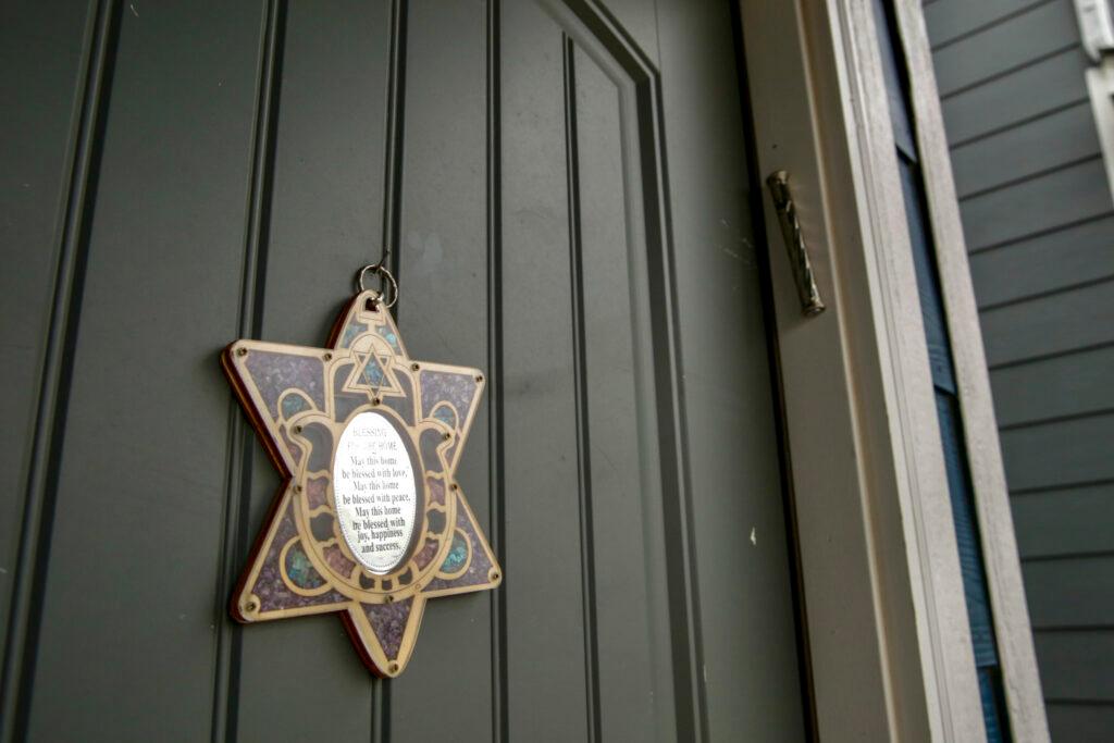 A close-up photo of a house’s front door displays a Star of David and a mezuzah.