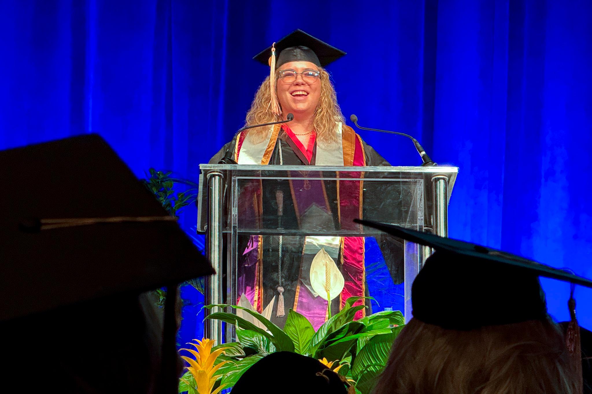A woman speaks at a graduation.