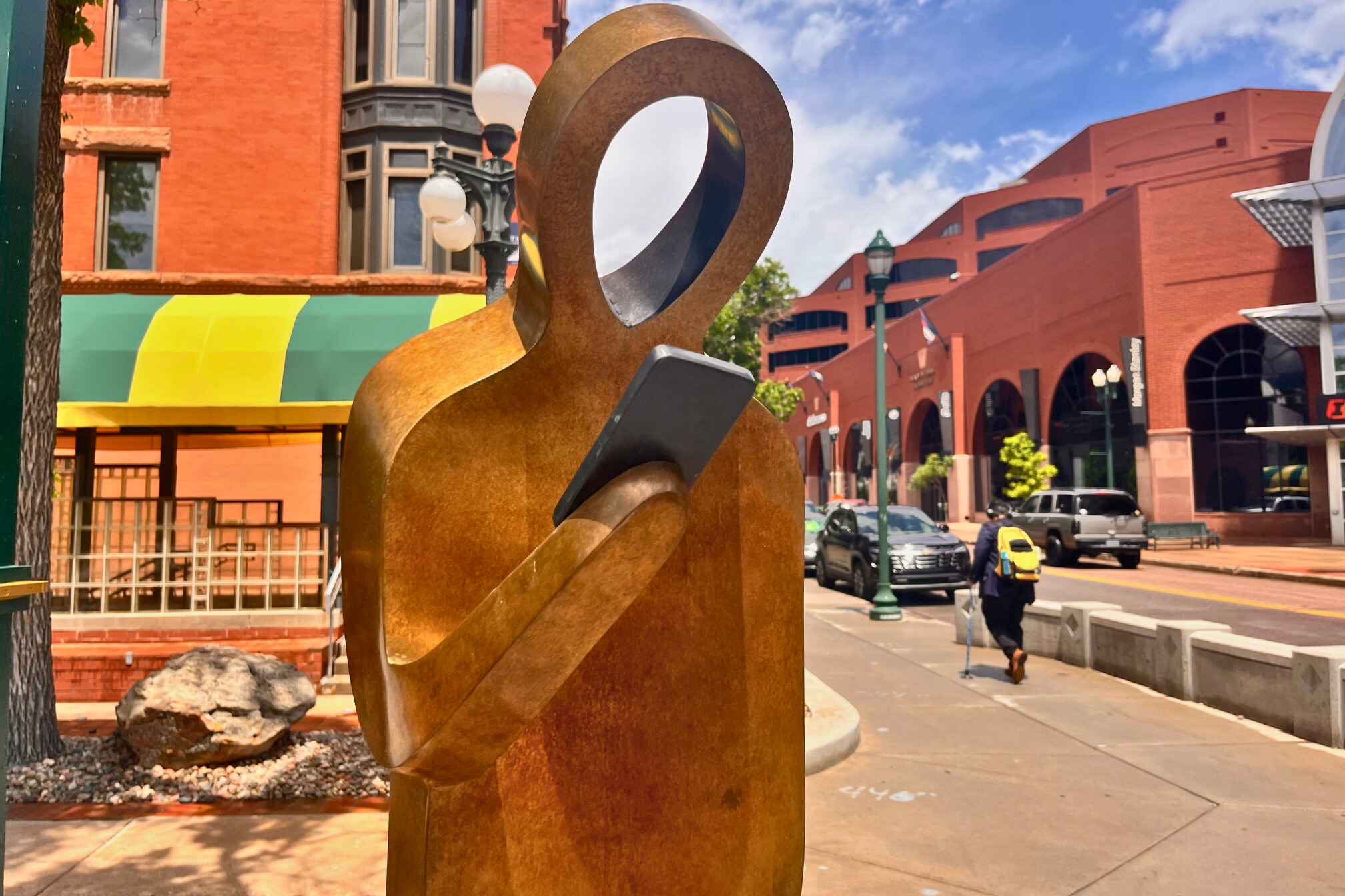 Sculpture of a human form holding a phone
