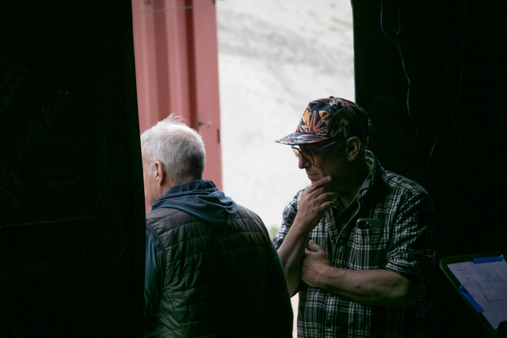 Executive Director James Paul (left) and Board Member Steve Lewis (right) stand at the entrance of The Tank. It's light outside and dark inside.