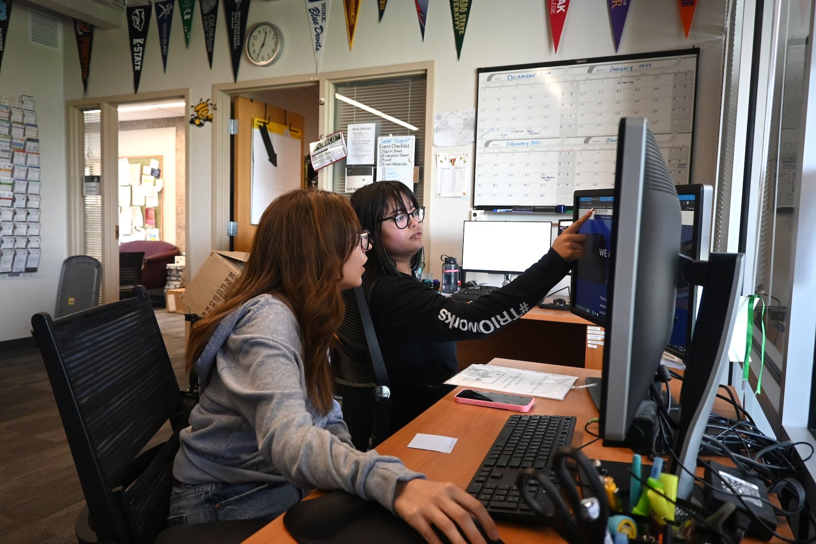 Two people look at a computer screen