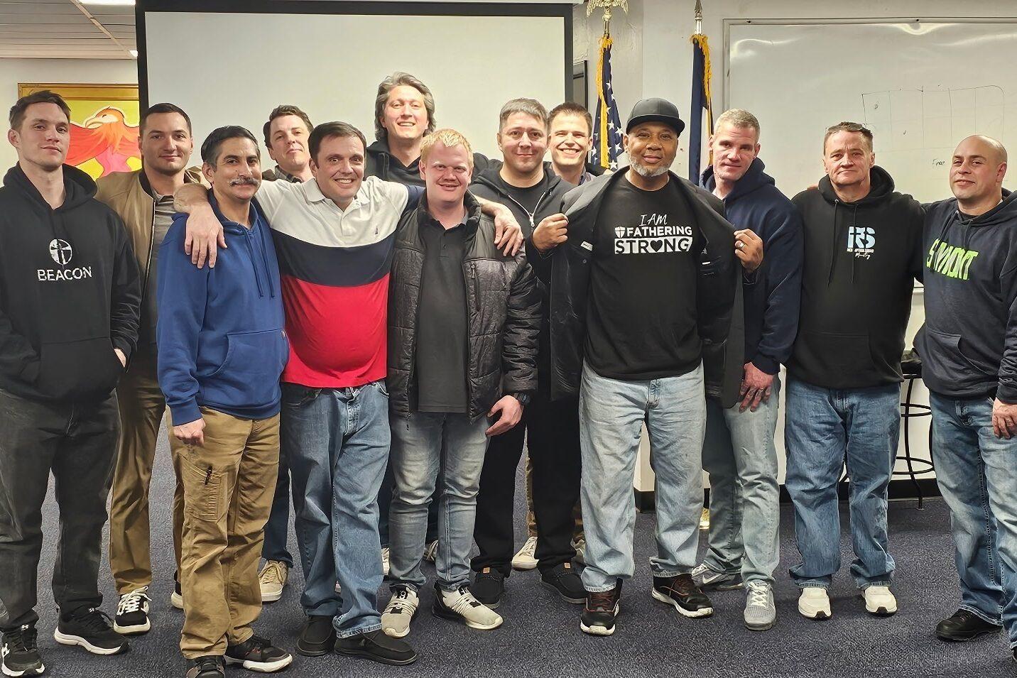 Photo shows a group of men standing together looing at the camera.