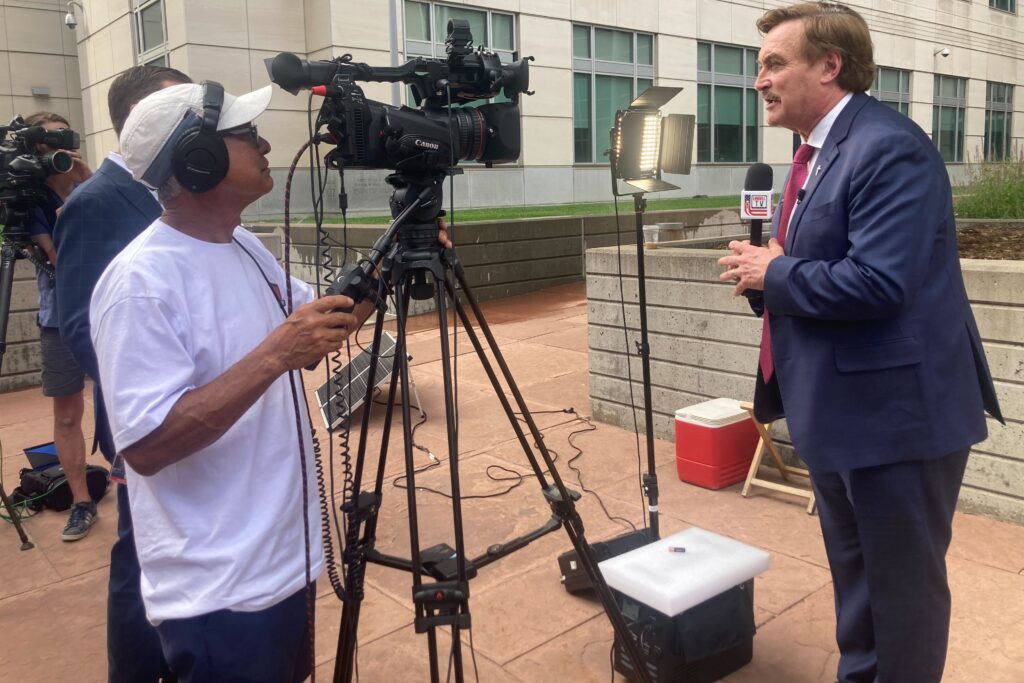 Man hold microphone and looks at camera