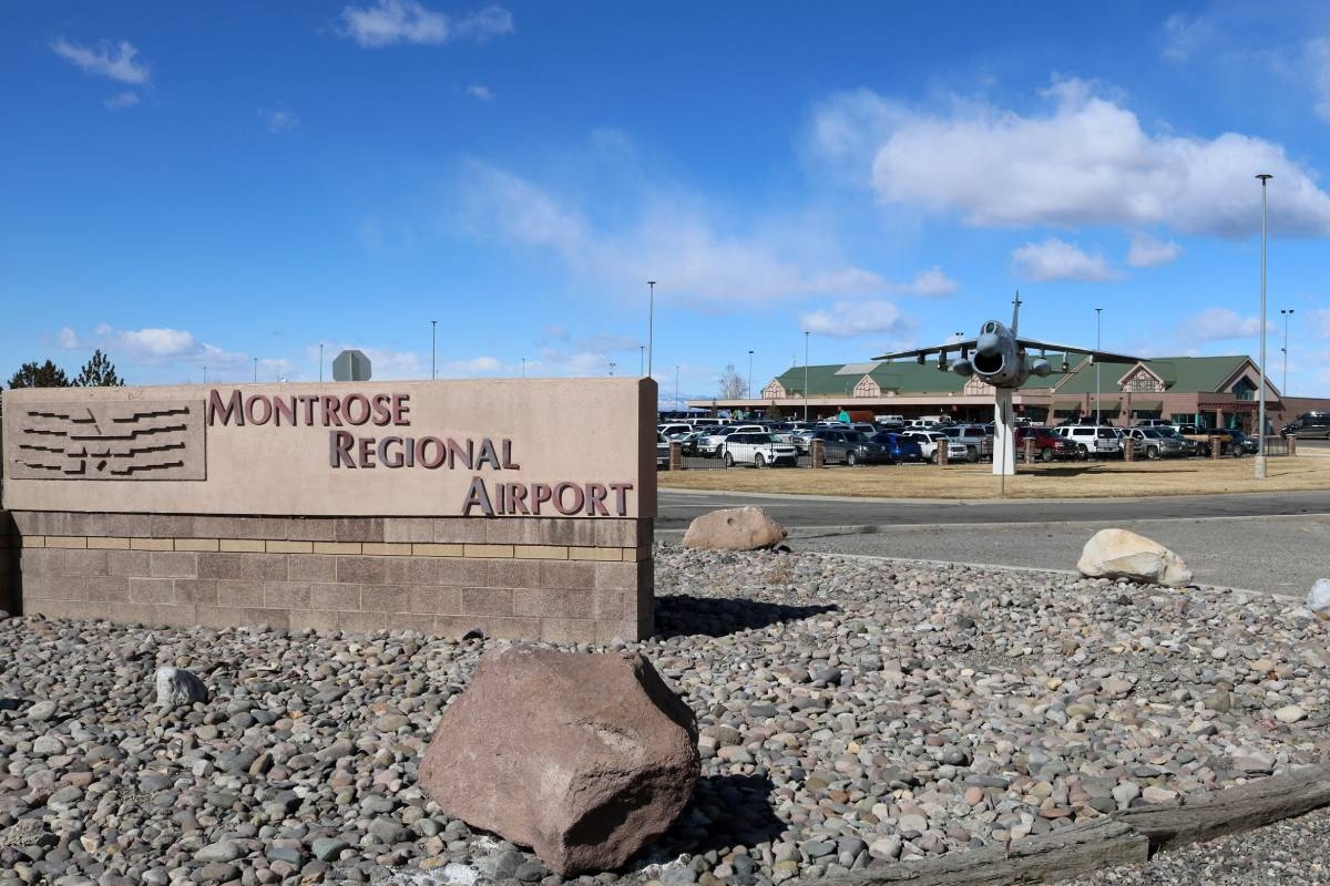 concrete sign in a rock field in front of an airport