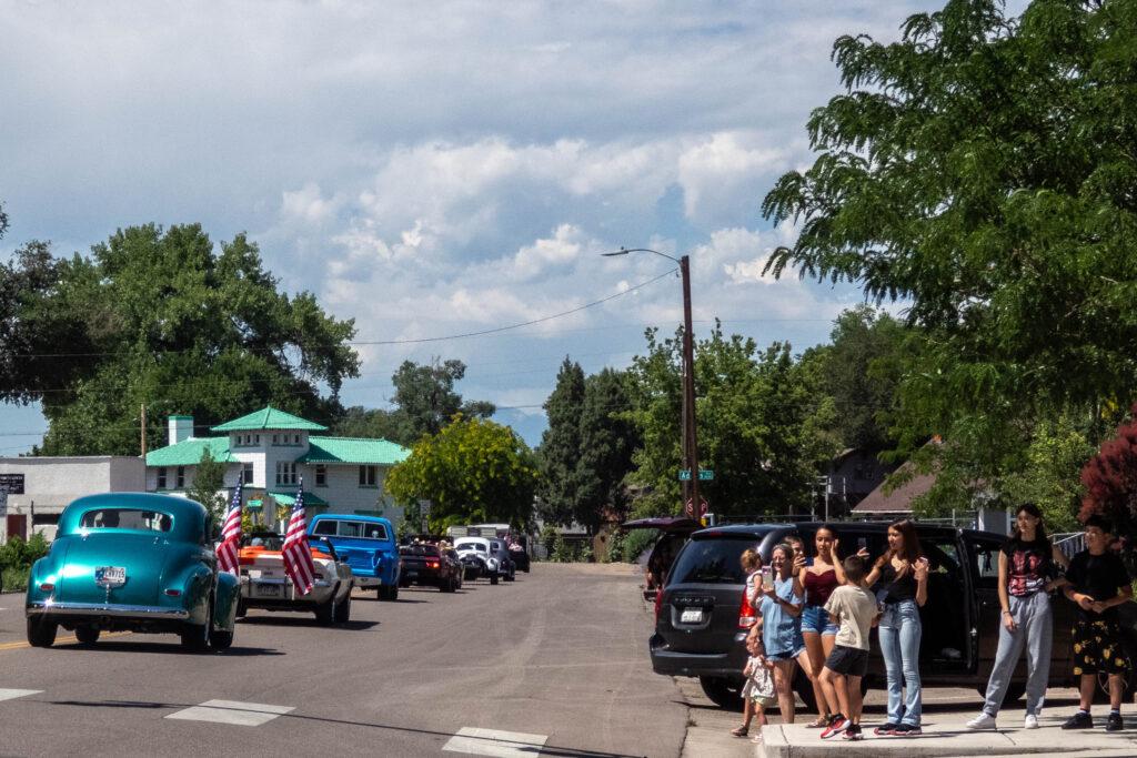 people watch parade of cars