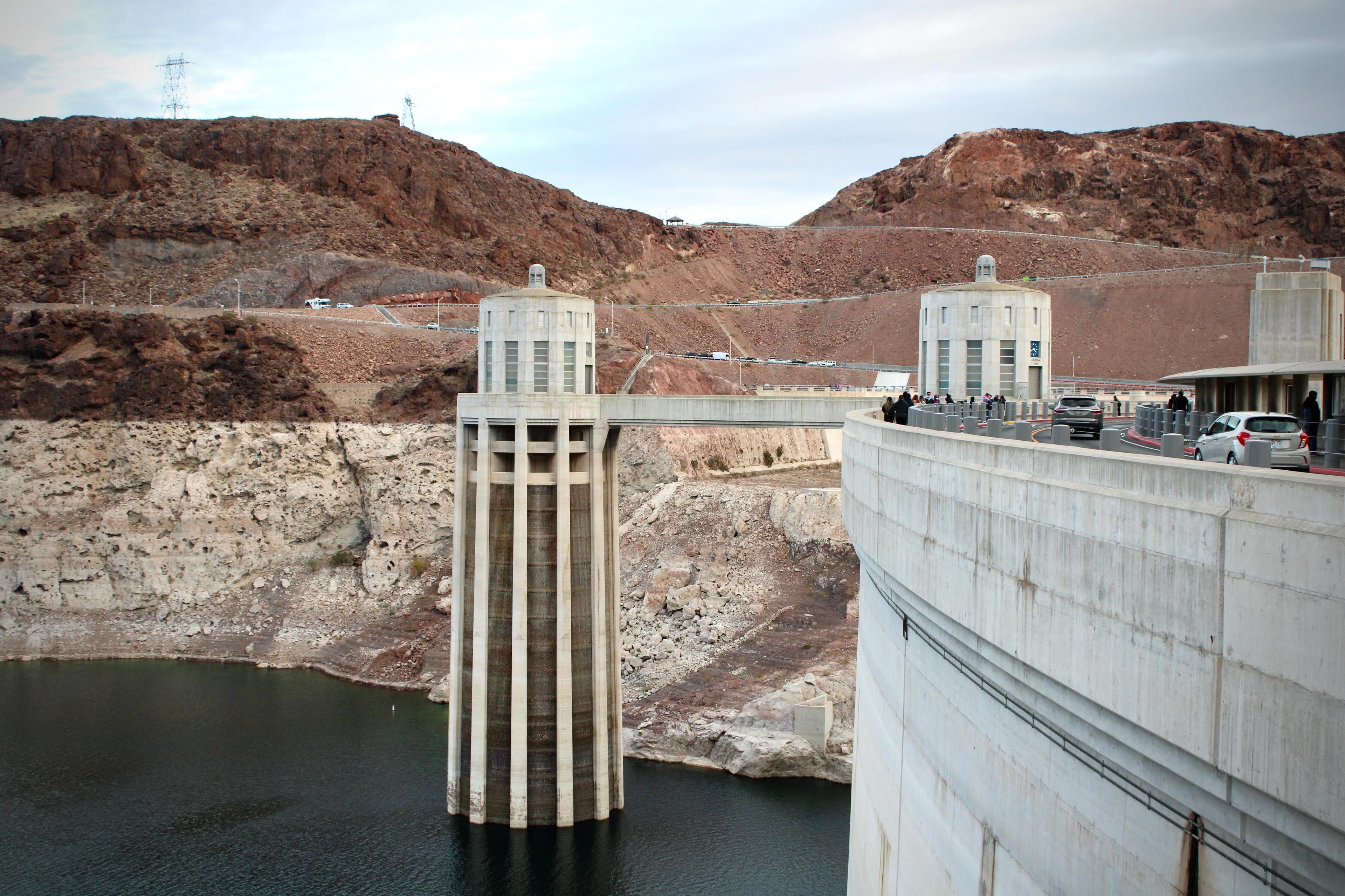 Water sits low behind a large concrete dam
