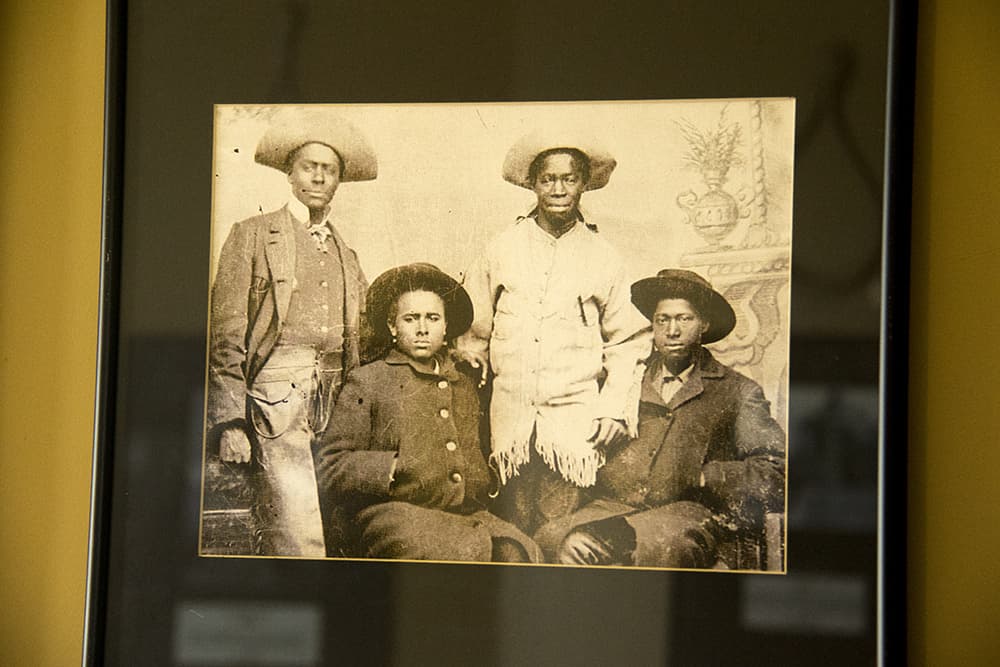 Historic black and white photo shows four Black men wearing hats in 1890.