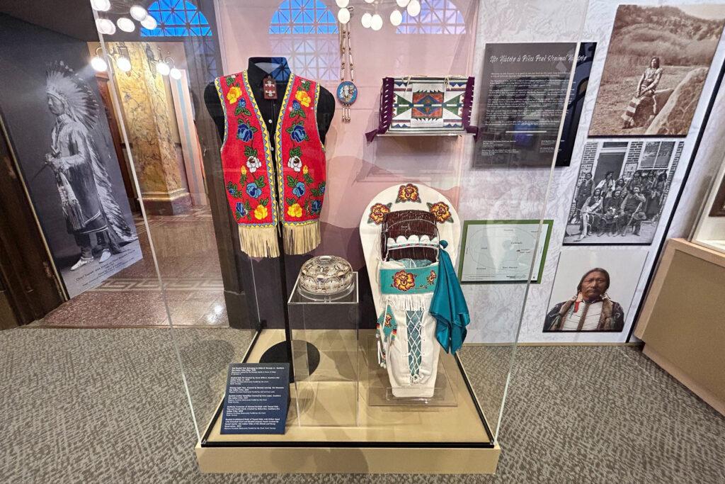 A vest, baby carrier, pottery, beadwork and other artifacts on display at the Pioneers Museum in Colorado Springs elevating Ute culture and history.