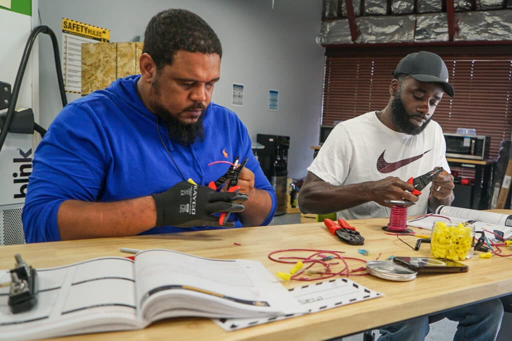 Two students work on a training exercise in a classroom