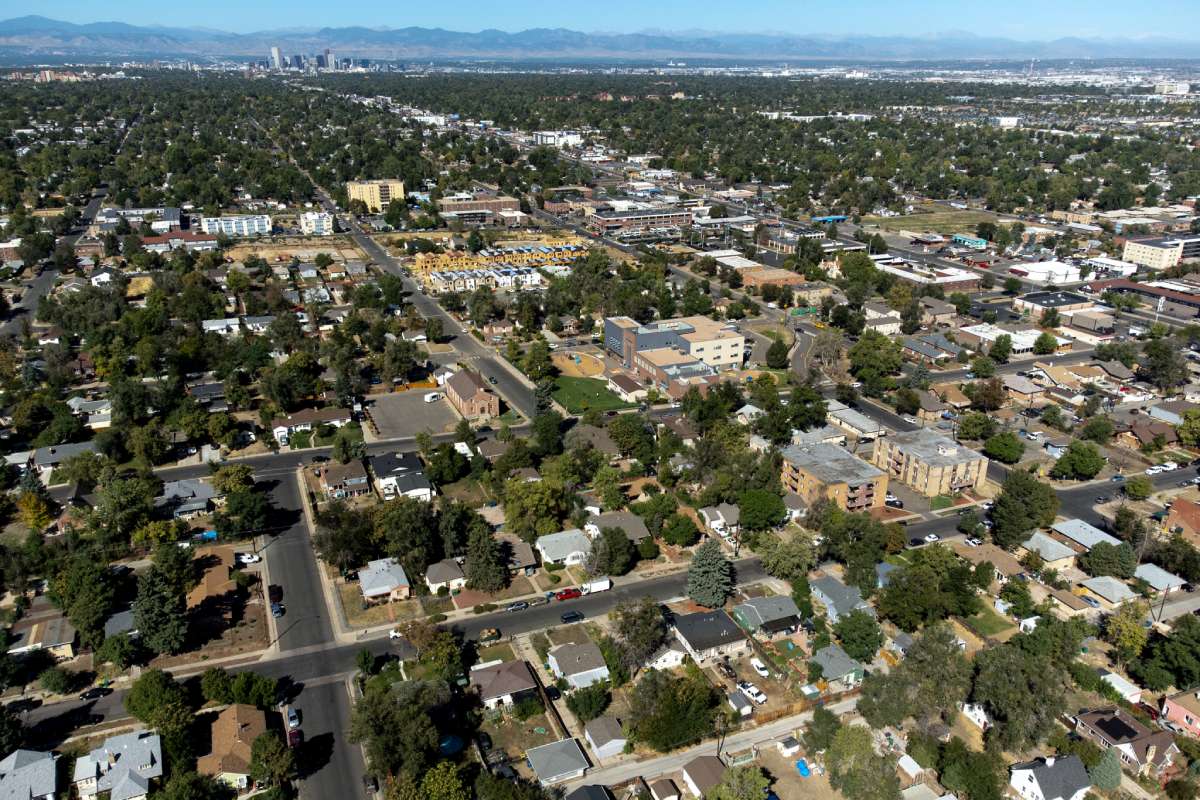 an aerial view of a neighborhood with a city and mountains in the background