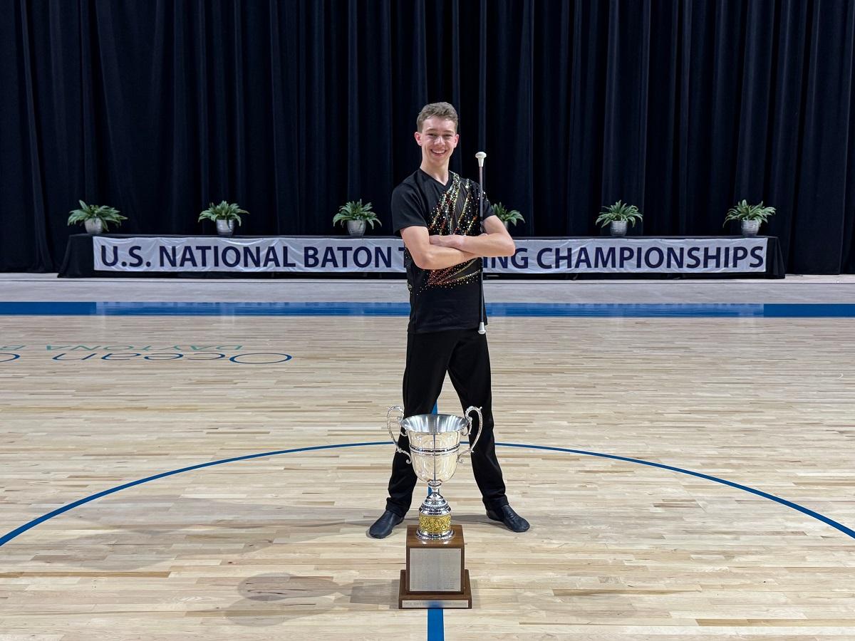 Person stands behind a trophy