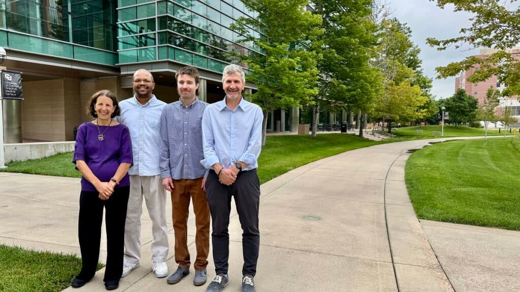 four people stand and pose for a photo