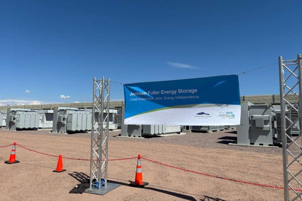 A banner in front of energy equipment in the background