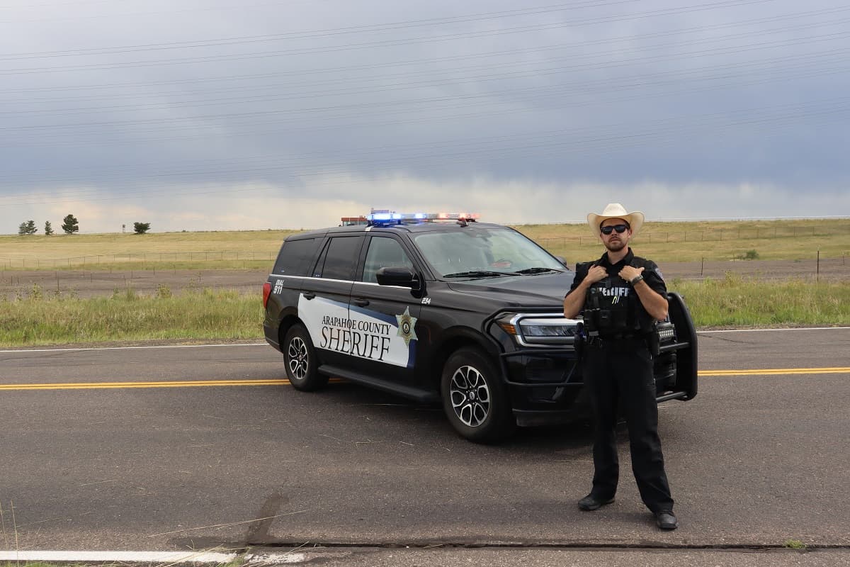 Person stands in front of a vehicle