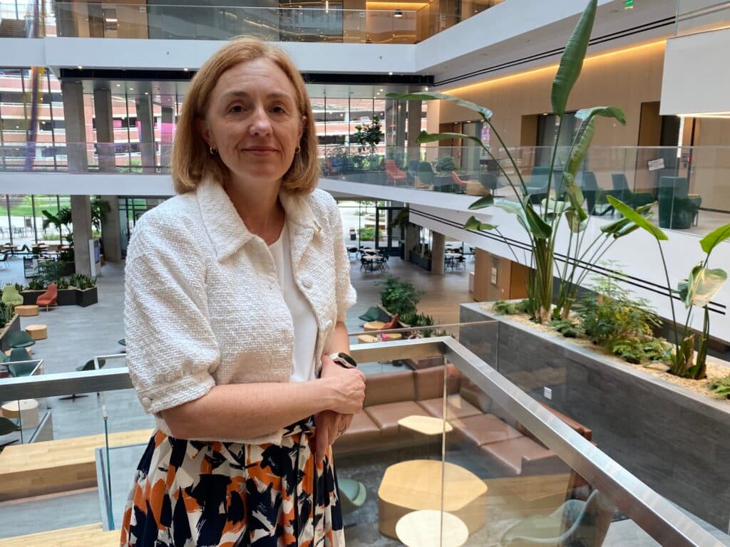 A woman stands in a lobby.