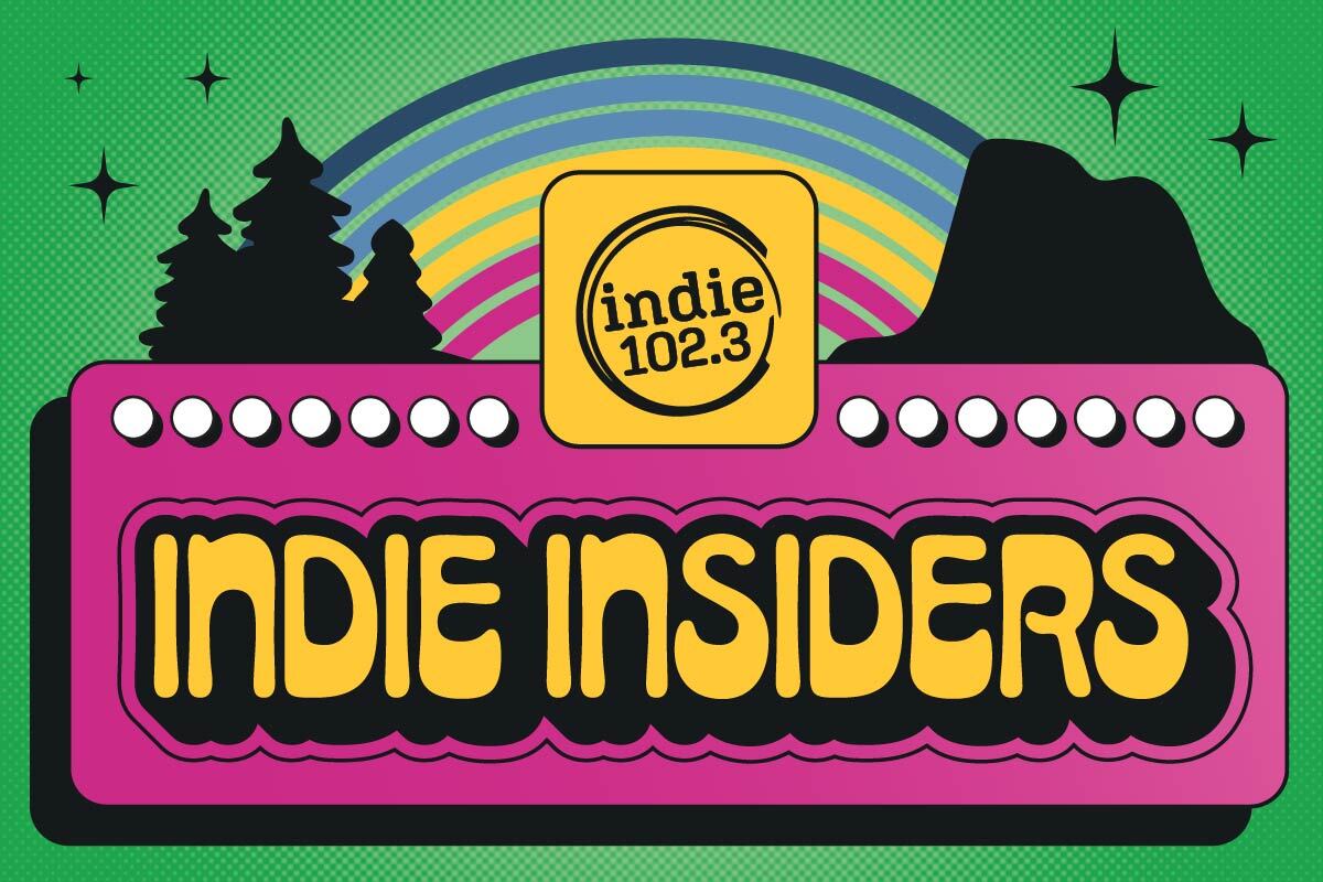 A bright pink marquee board says "Indie Insiders" with a kelly green background and mountains with a colorful rainbow