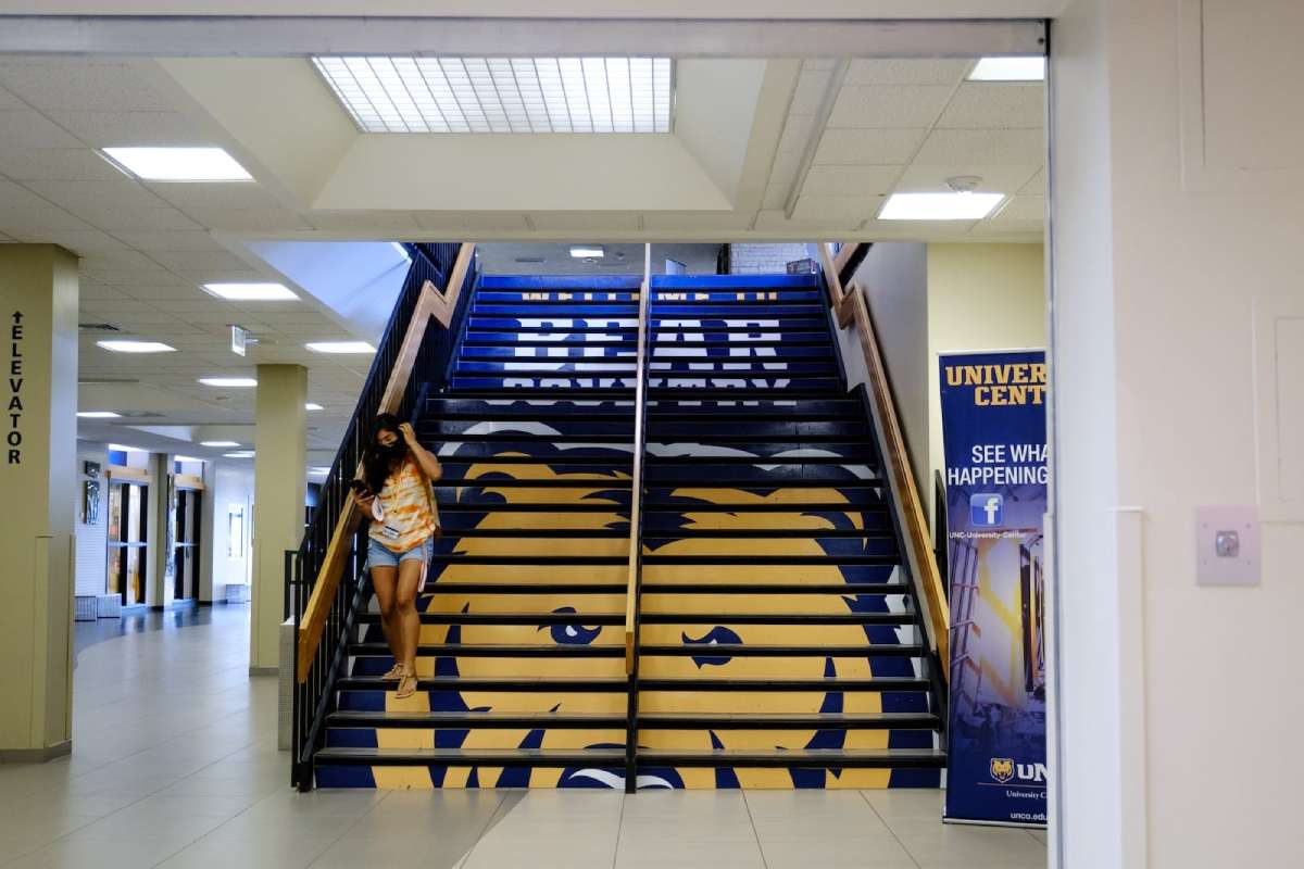 Stairs with the UNC masctor bear painted on it with a student walking down the right side