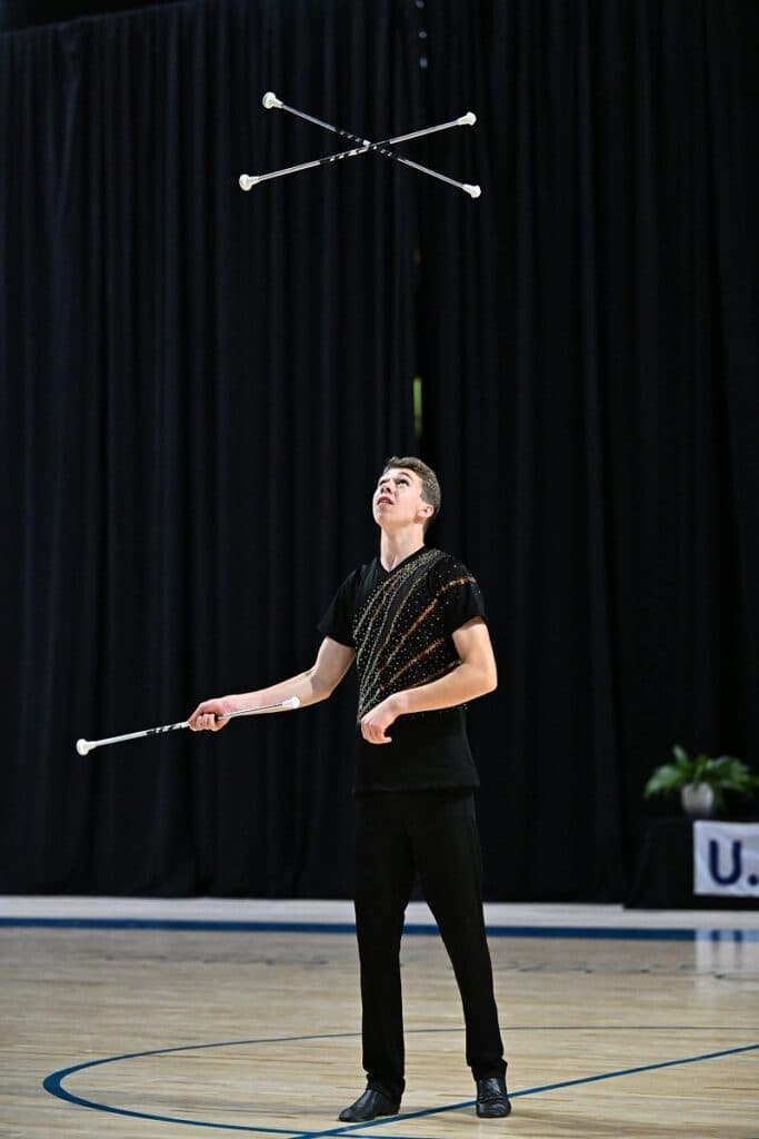 Person throwing batons in the air