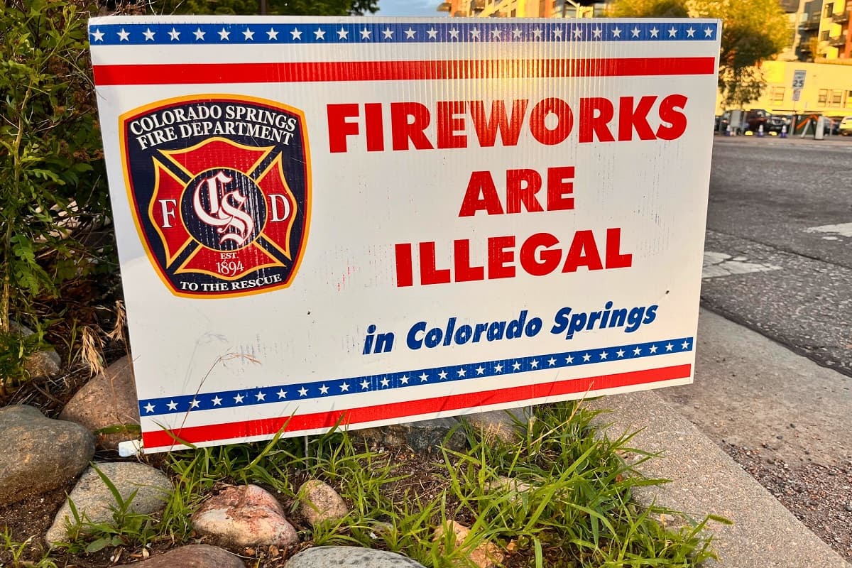 Sign planted on dirt near city street