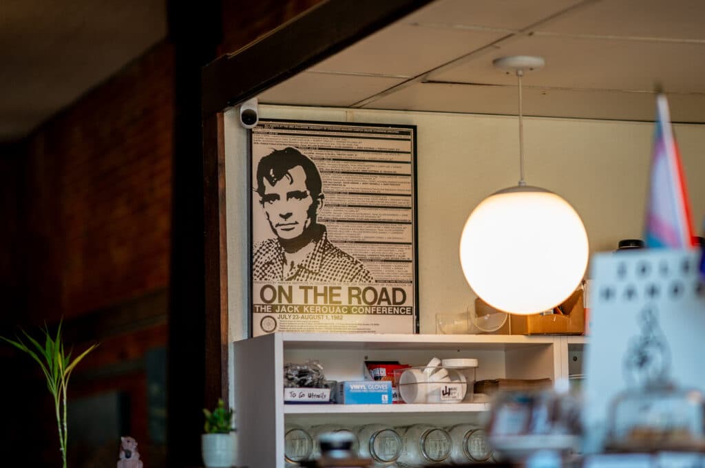 A poster promoting the 1982 On The Road: Jack Kerouac Conference sits above the coffee counter at Trident Booksellers on Pearl Street in Boulder