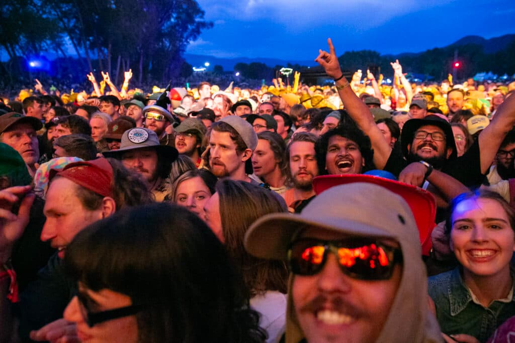 A packed crowd of thousnads floods the field in front of the stage.