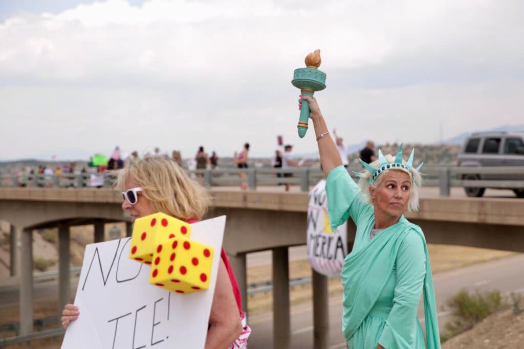 A woman dressed as the statue of liberty protests near a closed detention center in Huerfano County Colorado