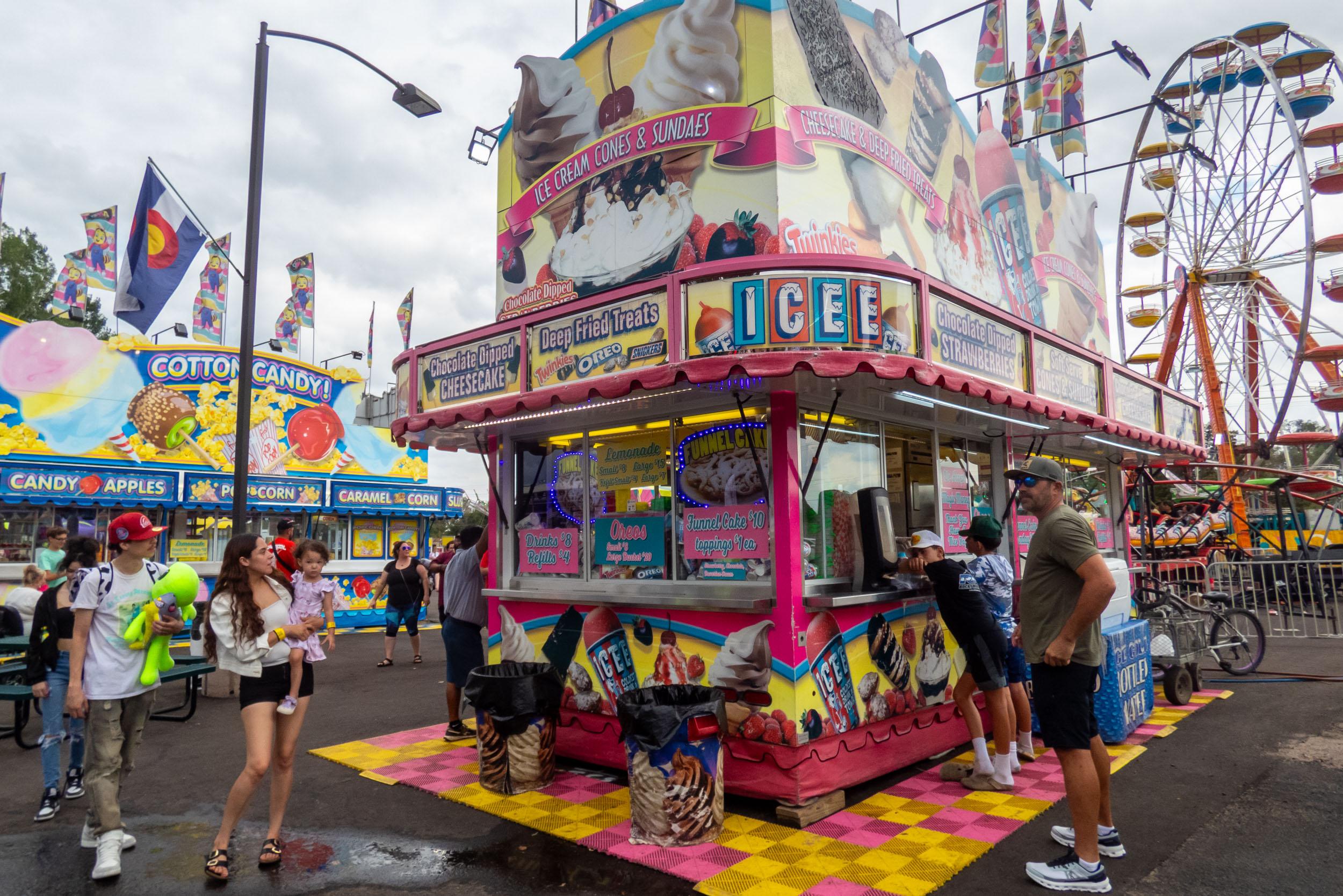 food vendor booths with carnival rides in the backround
