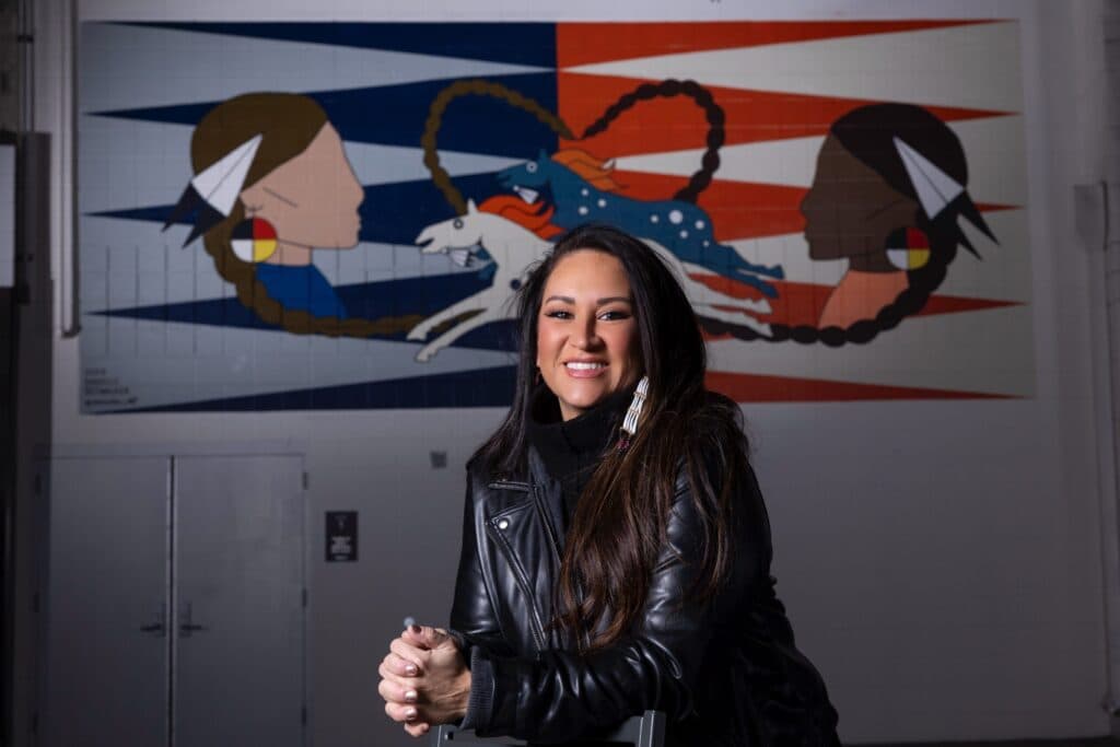 A woman in a leather jacket smiling at the camera
