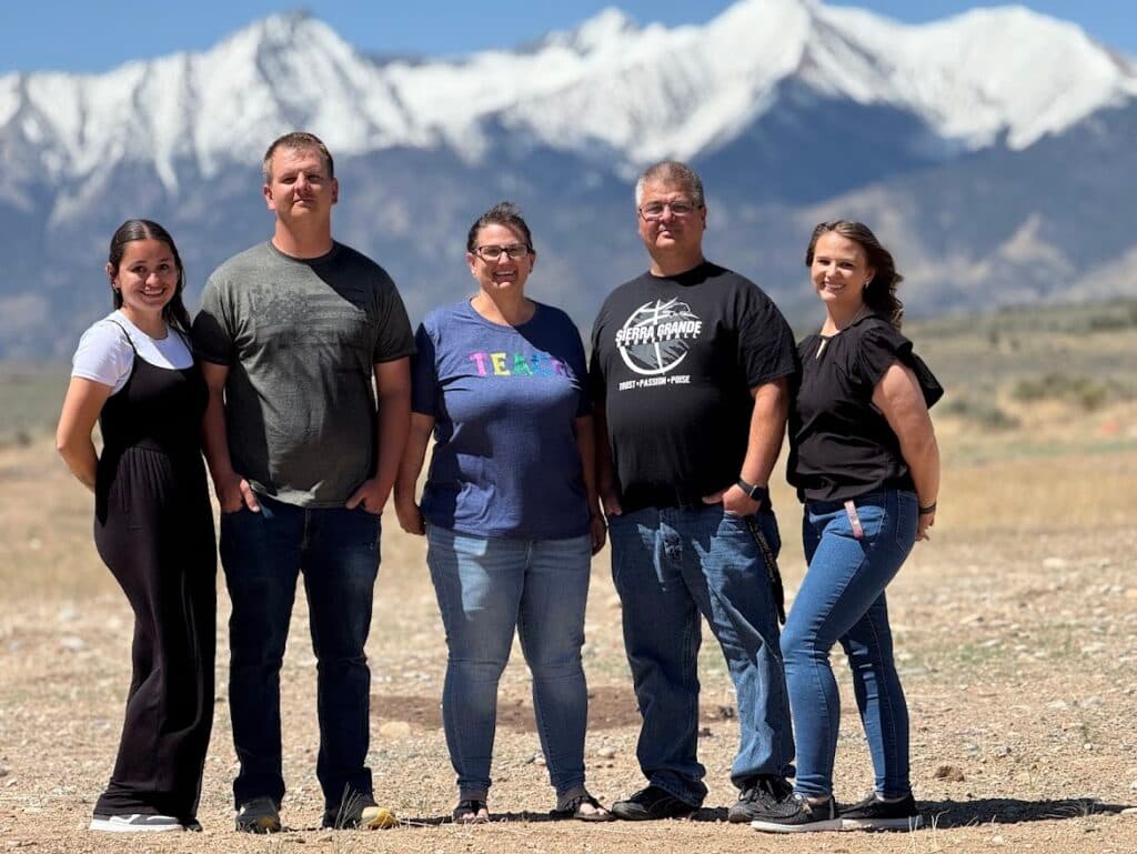 A family stands near a mountain.