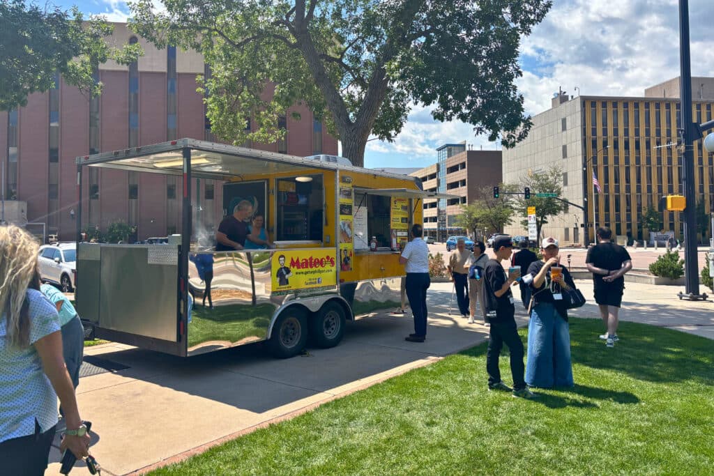 Group of people stand outside near a food truck