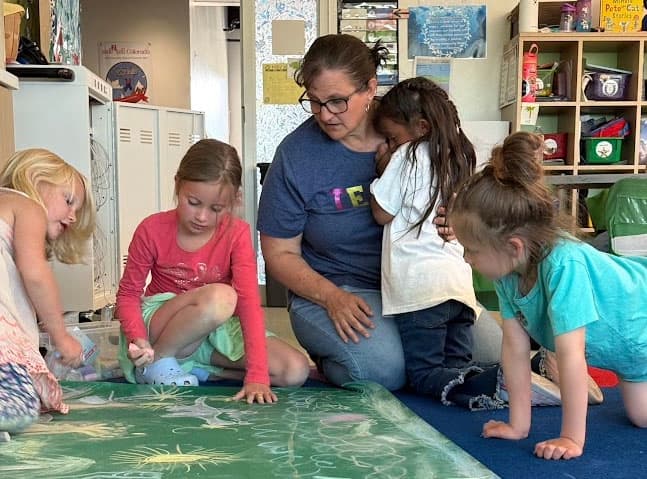 A teacher helps her students.