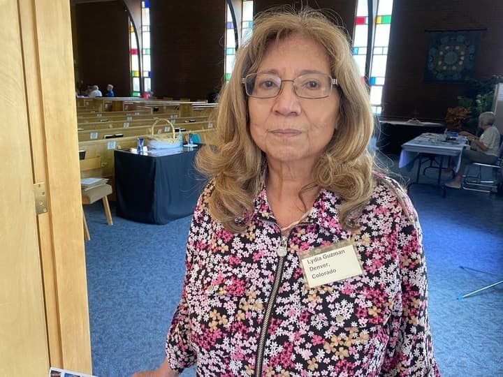 A woman in a floral print jacket poses for the camera at a recent event where a single payer healthcare system was discussed.