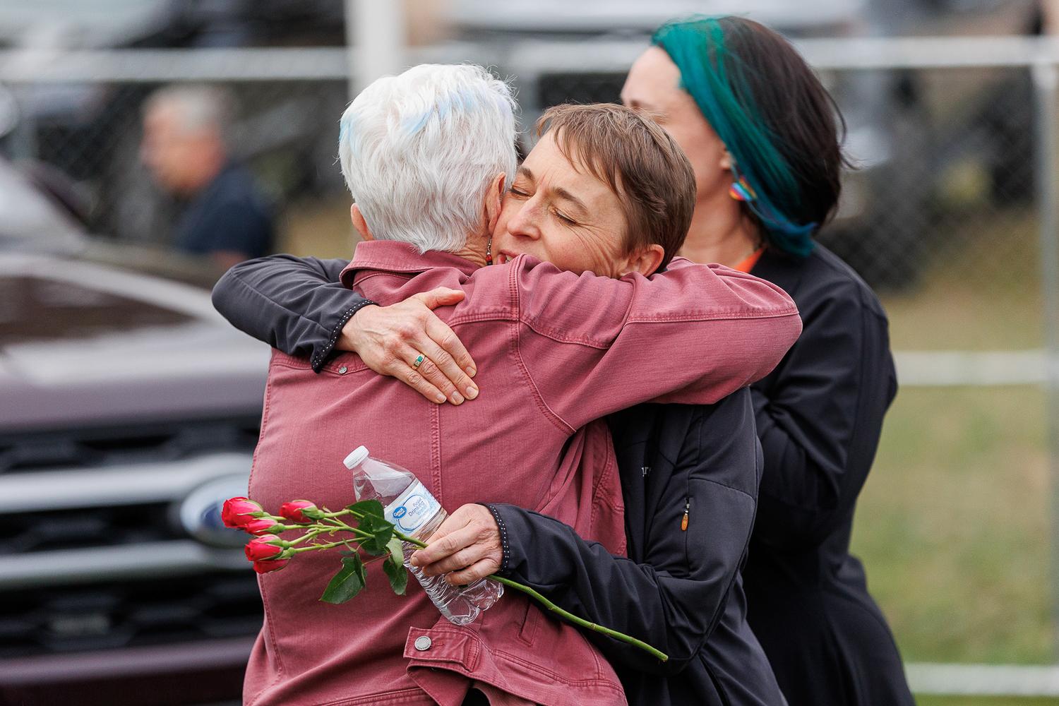 Evergreen High School Principal Skyler Artes hugs Jefferson County School Board President Mary Parker